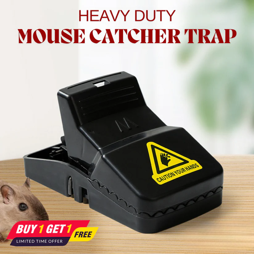 Heavy-duty mouse catcher trap with a warning label on a wooden surface.